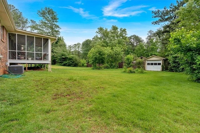 597 Rich Davis Rd, Hiram, GA 30141 - view of grassy yard with cooling unit, a sunroom, an outbuilding, and a detached garage