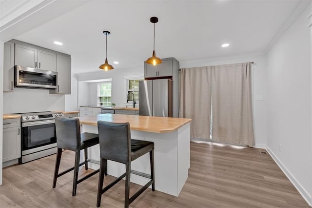 597 Rich Davis Rd, Hiram, GA 30141 - kitchen with stainless steel appliances, gray cabinetry, butcher block counters, light wood finished floors, and ornamental molding