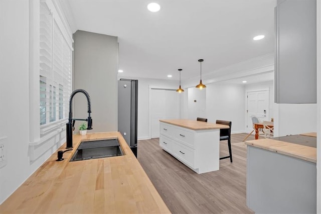 597 Rich Davis Rd, Hiram, GA 30141 - kitchen featuring a sink, a breakfast bar area, freestanding refrigerator, recessed lighting, and white cabinets