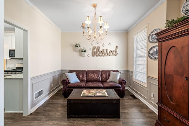 49 Inverness Ct, Hiram, GA 30141 - living room featuring a chandelier, ornamental molding, dark wood-type flooring, wainscoting, and a decorative wall