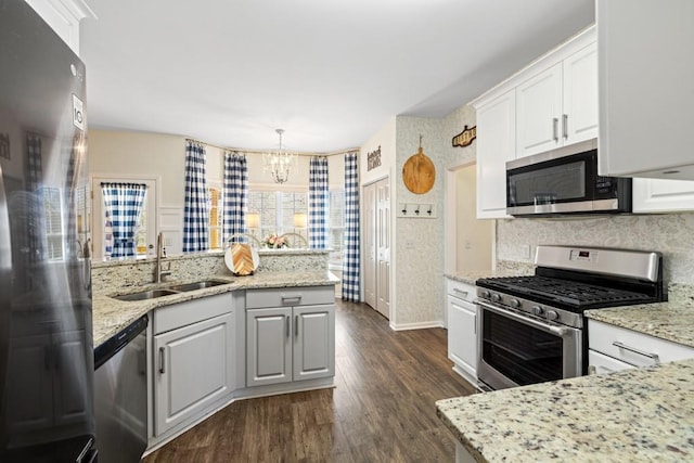 49 Inverness Ct, Hiram, GA 30141 - kitchen featuring appliances with stainless steel finishes, a sink, dark wood-style floors, a peninsula, and a chandelier