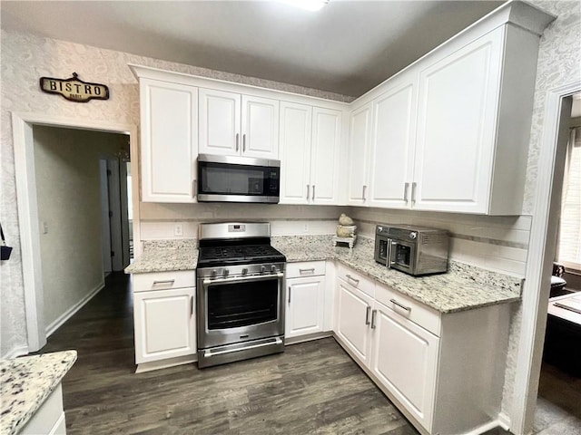 49 Inverness Ct, Hiram, GA 30141 - kitchen featuring appliances with stainless steel finishes, white cabinetry, dark wood-type flooring, and light stone counters