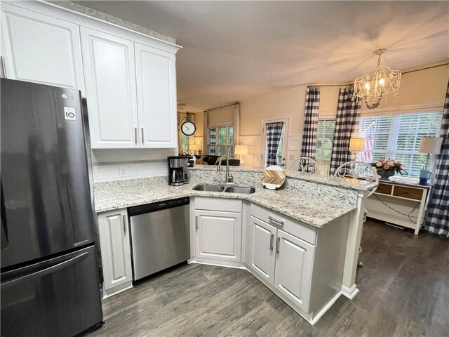 49 Inverness Ct, Hiram, GA 30141 - kitchen with freestanding refrigerator, stainless steel dishwasher, a sink, a peninsula, and dark wood-style floors