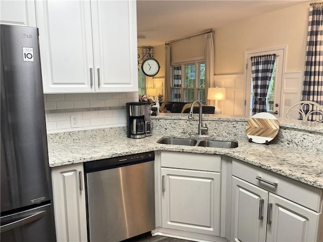 49 Inverness Ct, Hiram, GA 30141 - kitchen with stainless steel appliances, a sink, decorative backsplash, white cabinetry, and light stone counters