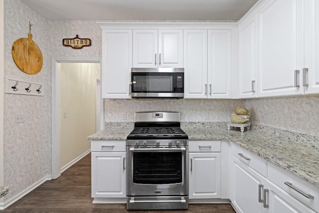 49 Inverness Ct, Hiram, GA 30141 - kitchen featuring appliances with stainless steel finishes, wallpapered walls, baseboards, and white cabinets