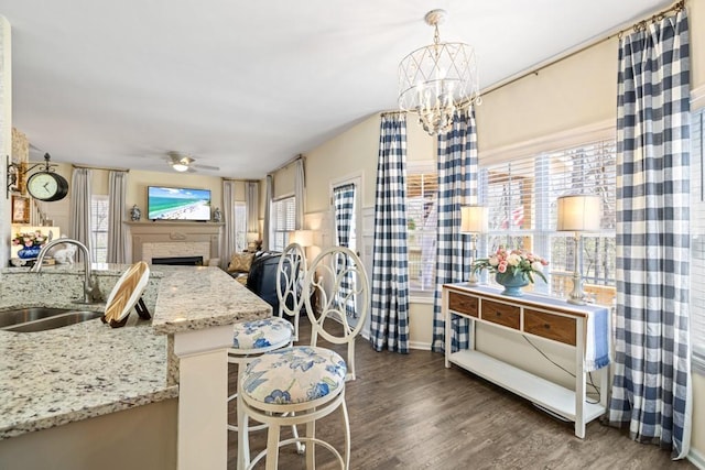 49 Inverness Ct, Hiram, GA 30141 - kitchen featuring a sink, a fireplace, wood finished floors, ceiling fan, and a chandelier