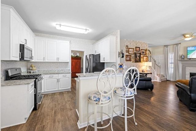 49 Inverness Ct, Hiram, GA 30141 - kitchen with appliances with stainless steel finishes, open floor plan, white cabinets, decorative backsplash, and a peninsula