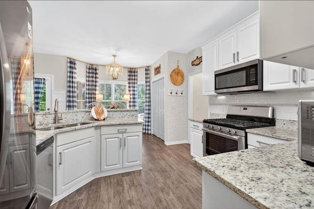 49 Inverness Ct, Hiram, GA 30141 - kitchen with appliances with stainless steel finishes, a peninsula, white cabinetry, and a chandelier