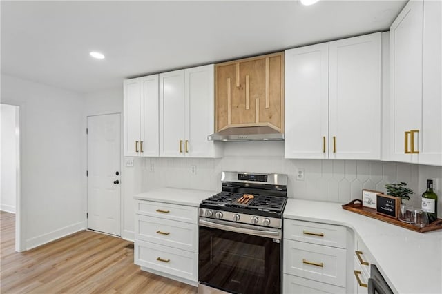 kitchen with tasteful backsplash, light wood-type flooring, gas stove, and white cabinets