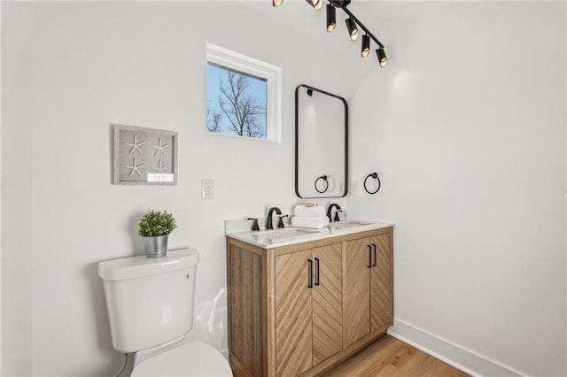 bathroom with vanity, toilet, and wood-type flooring