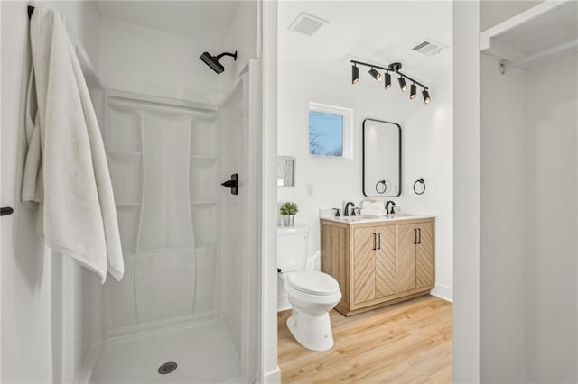 bathroom featuring vanity, hardwood / wood-style floors, toilet, and walk in shower