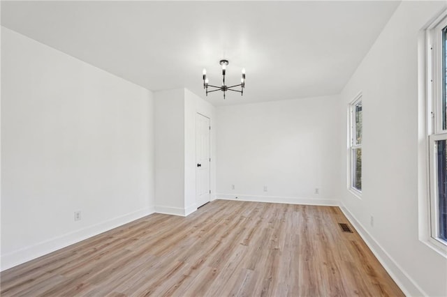 unfurnished dining area with an inviting chandelier and light hardwood / wood-style flooring