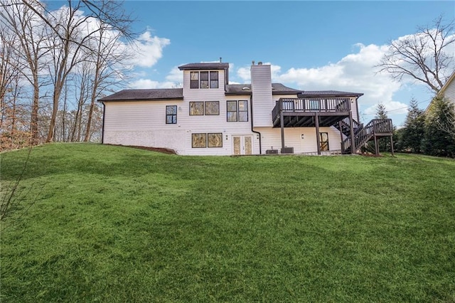 rear view of house with a yard and a deck