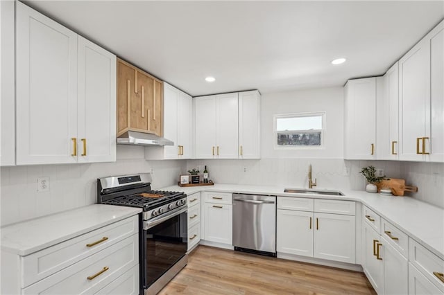 kitchen featuring sink, white cabinetry, tasteful backsplash, light hardwood / wood-style flooring, and appliances with stainless steel finishes