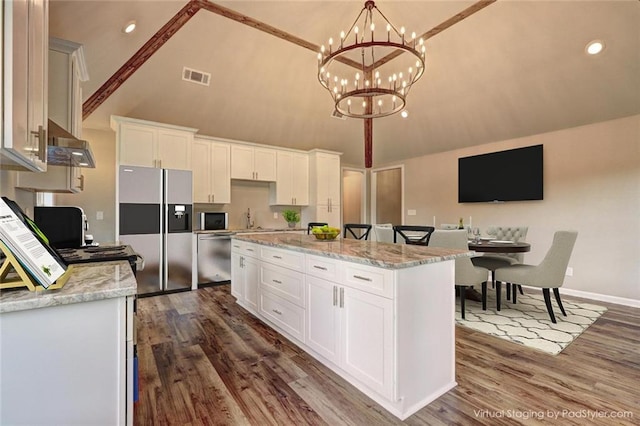 kitchen featuring appliances with stainless steel finishes, a center island, dark hardwood / wood-style flooring, white cabinets, and an inviting chandelier