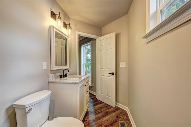 bathroom with toilet, vanity, and hardwood / wood-style flooring