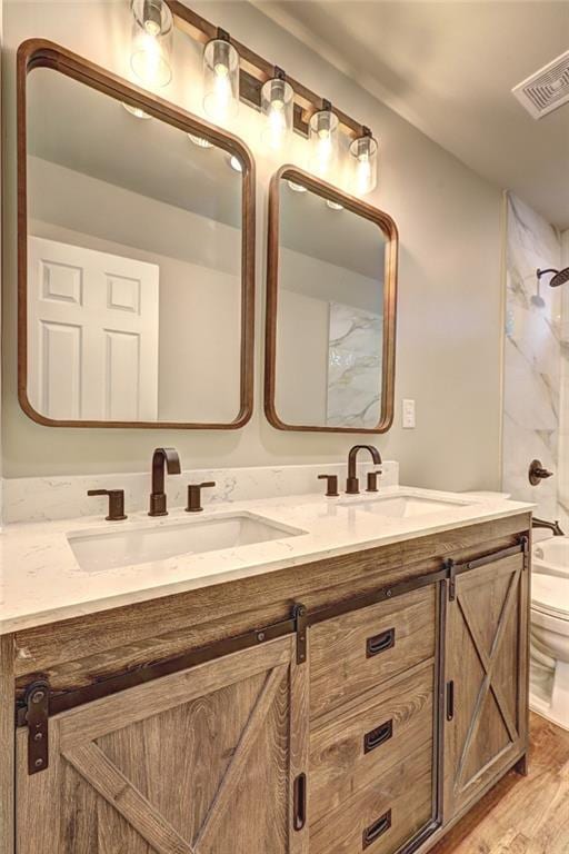 full bathroom with shower / washtub combination, toilet, vanity, and hardwood / wood-style flooring