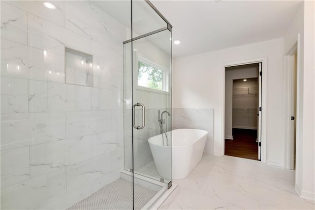 200 College Ave, Commerce, GA 30529 - bathroom with a soaking tub, marble finish floors, a stall shower, and a walk in closet