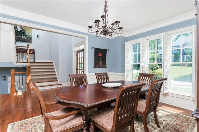 dining space featuring hardwood / wood-style floors, a notable chandelier, and ornamental molding