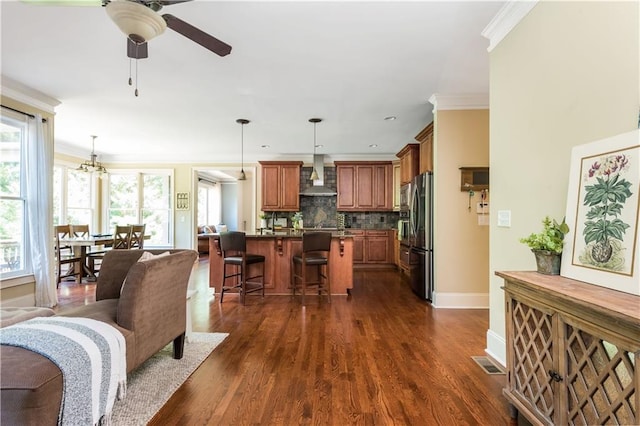 living room featuring ornamental molding, ceiling fan with notable chandelier, and dark wood-type flooring