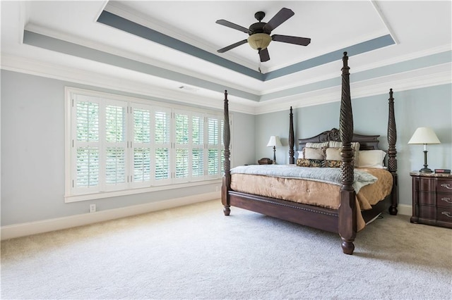 carpeted bedroom featuring ceiling fan, a raised ceiling, and crown molding