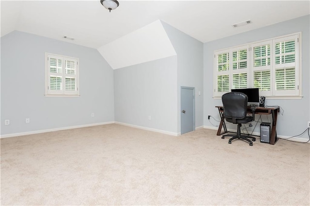 carpeted home office featuring vaulted ceiling