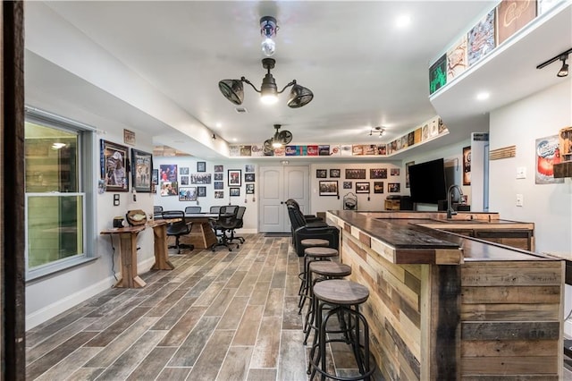 bar with wood-type flooring and sink