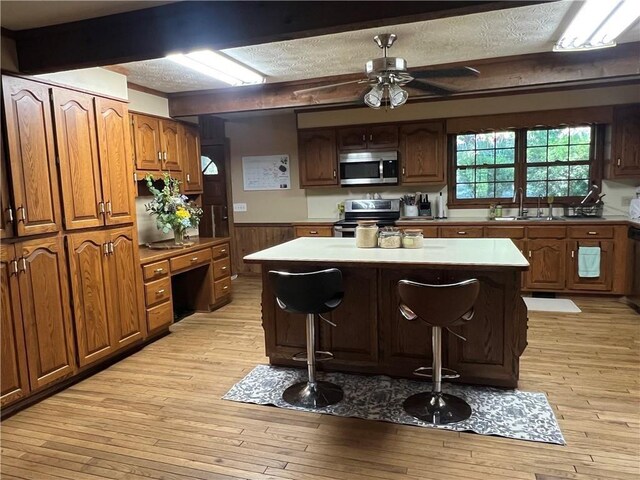 6245 Bannister Rd, Cumming, GA 30028 - kitchen with light wood-style flooring, a sink, a kitchen island, a kitchen breakfast bar, and appliances with stainless steel finishes