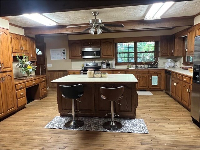 6245 Bannister Rd, Cumming, GA 30028 - kitchen featuring light countertops, appliances with stainless steel finishes, a kitchen island, and a breakfast bar
