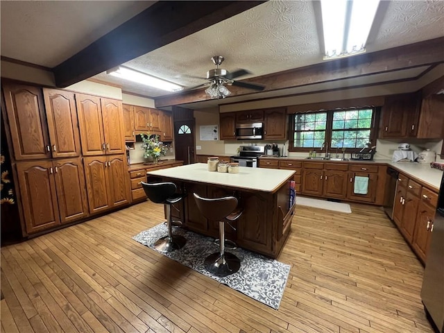 6245 Bannister Rd, Cumming, GA 30028 - kitchen featuring light countertops, appliances with stainless steel finishes, a breakfast bar area, and a kitchen island