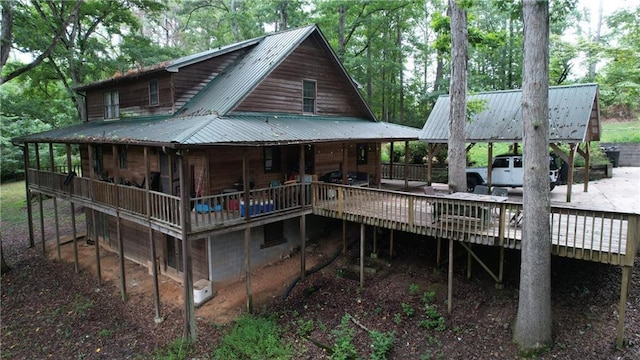 back of property with metal roof and a wooden deck