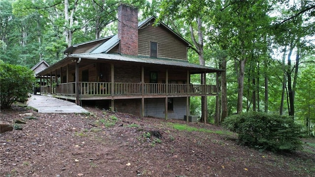 6245 Bannister Rd, Cumming, GA 30028 - view of home's exterior with metal roof, a chimney, and cooling unit