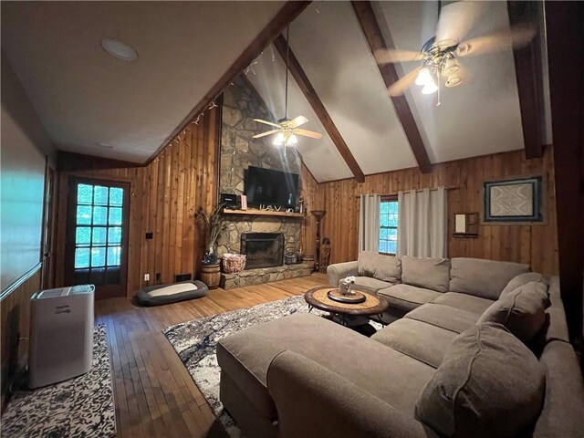 6245 Bannister Rd, Cumming, GA 30028 - living room with wooden walls, beamed ceiling, wood finished floors, a stone fireplace, and high vaulted ceiling