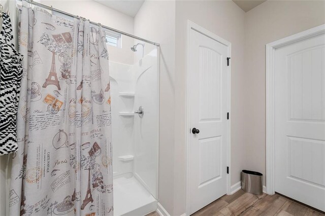 bathroom featuring hardwood / wood-style flooring and walk in shower