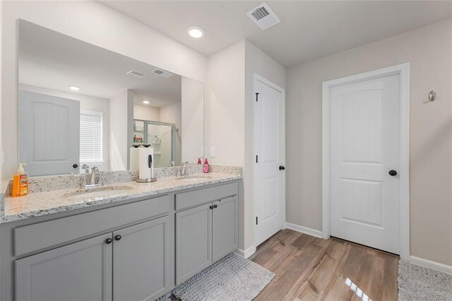 bathroom with vanity, walk in shower, and hardwood / wood-style flooring