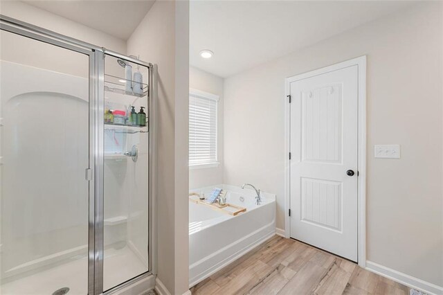 bathroom with wood-type flooring and separate shower and tub