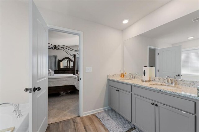 bathroom with vanity, hardwood / wood-style flooring, and a bathtub