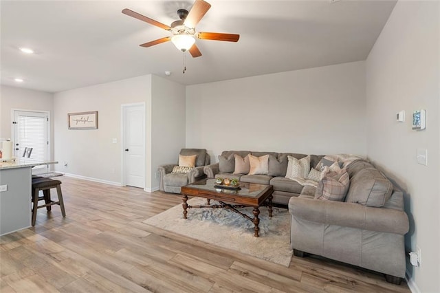 living room with light hardwood / wood-style flooring and ceiling fan