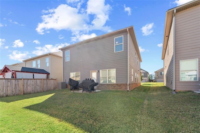 rear view of property featuring a yard and cooling unit