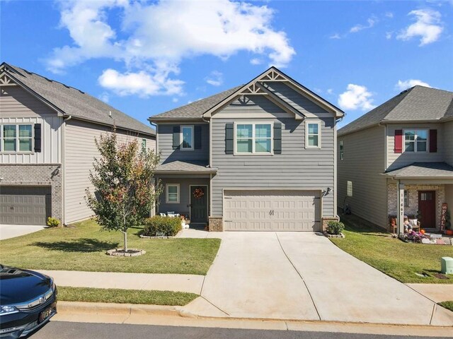 craftsman inspired home featuring a front yard and a garage