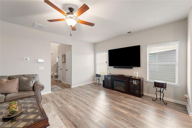 living room featuring ceiling fan and light hardwood / wood-style flooring