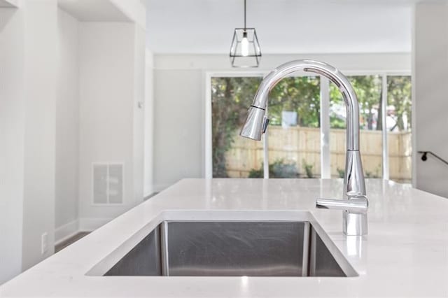 interior space featuring sink and hanging light fixtures