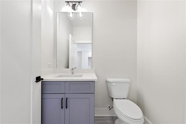 bathroom featuring vanity, toilet, and hardwood / wood-style flooring