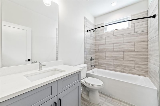 full bathroom featuring toilet, tiled shower / bath combo, and vanity