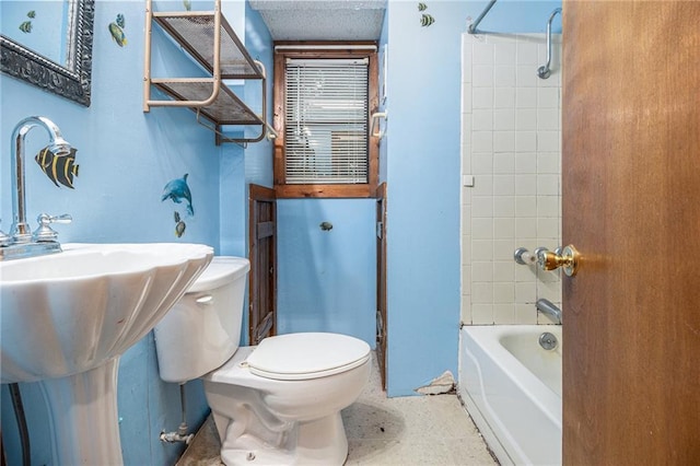 bathroom featuring tiled shower / bath and toilet