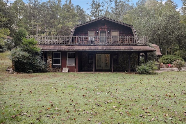 view of front of home with a front lawn, french doors, and a deck