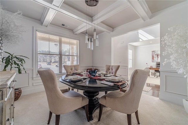 dining space with beam ceiling, plenty of natural light, and a decorative wall