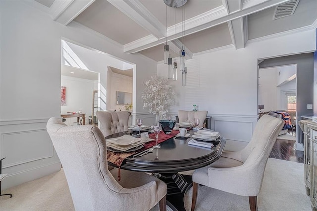 dining area featuring beam ceiling, a decorative wall, crown molding, and visible vents