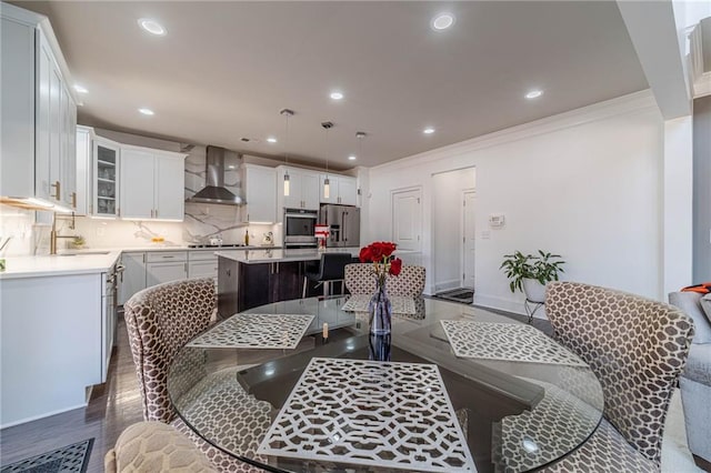 dining area with recessed lighting, dark wood-type flooring, and ornamental molding