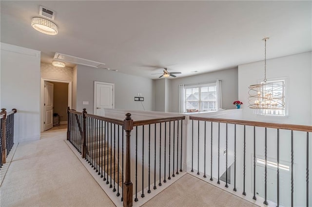 hallway featuring visible vents, light carpet, attic access, and an upstairs landing